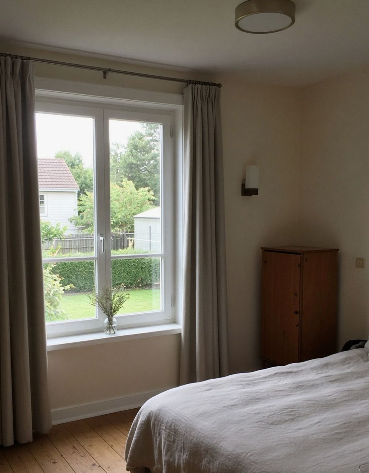 Chambre, fenêtre sur haie et abri blanc, vase de fleurs séchées