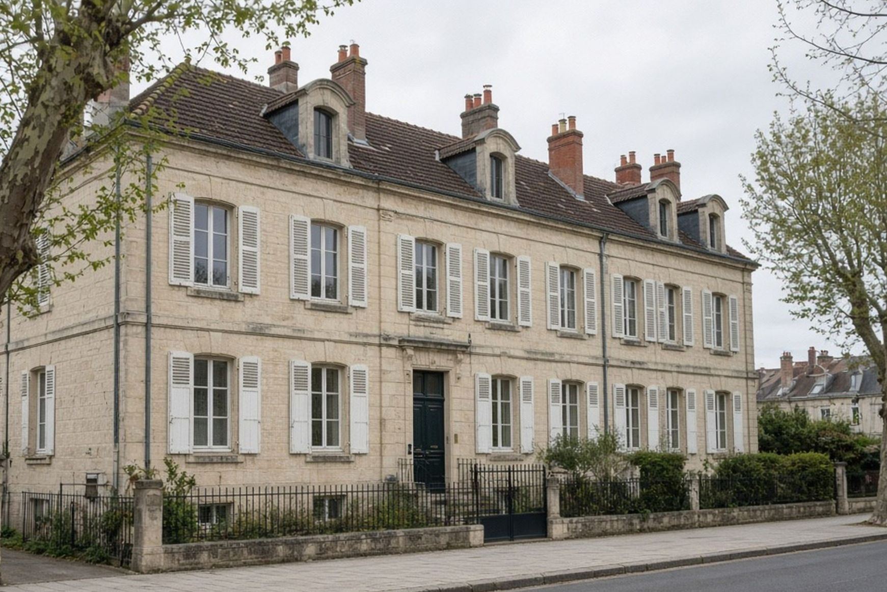 Façade en pierre de trois étages, volets blancs, Rue Christophe Colomb